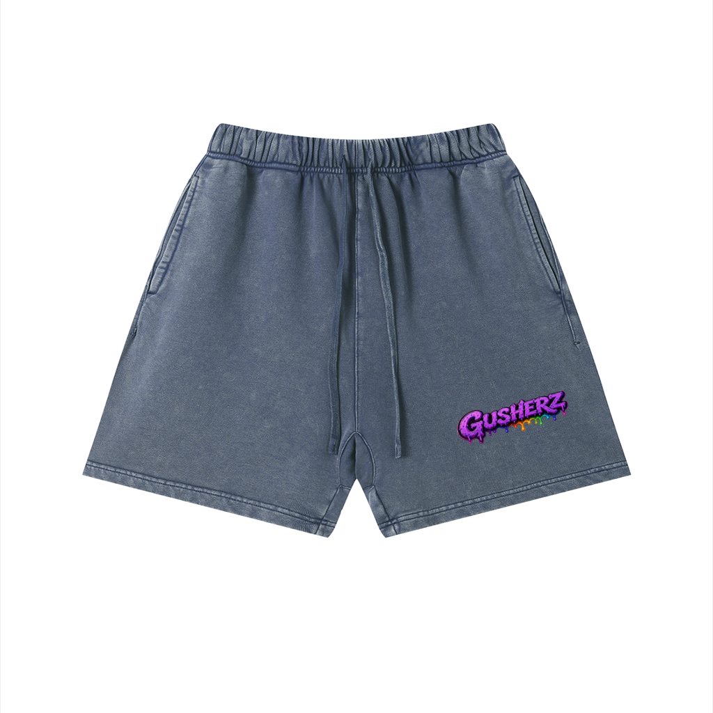 A pair of NFEO ZAZA Reserve faded blue denim shorts with a drawstring waist and a colorful 'GUSHERZ' logo on the left leg, displayed against a plain white background.