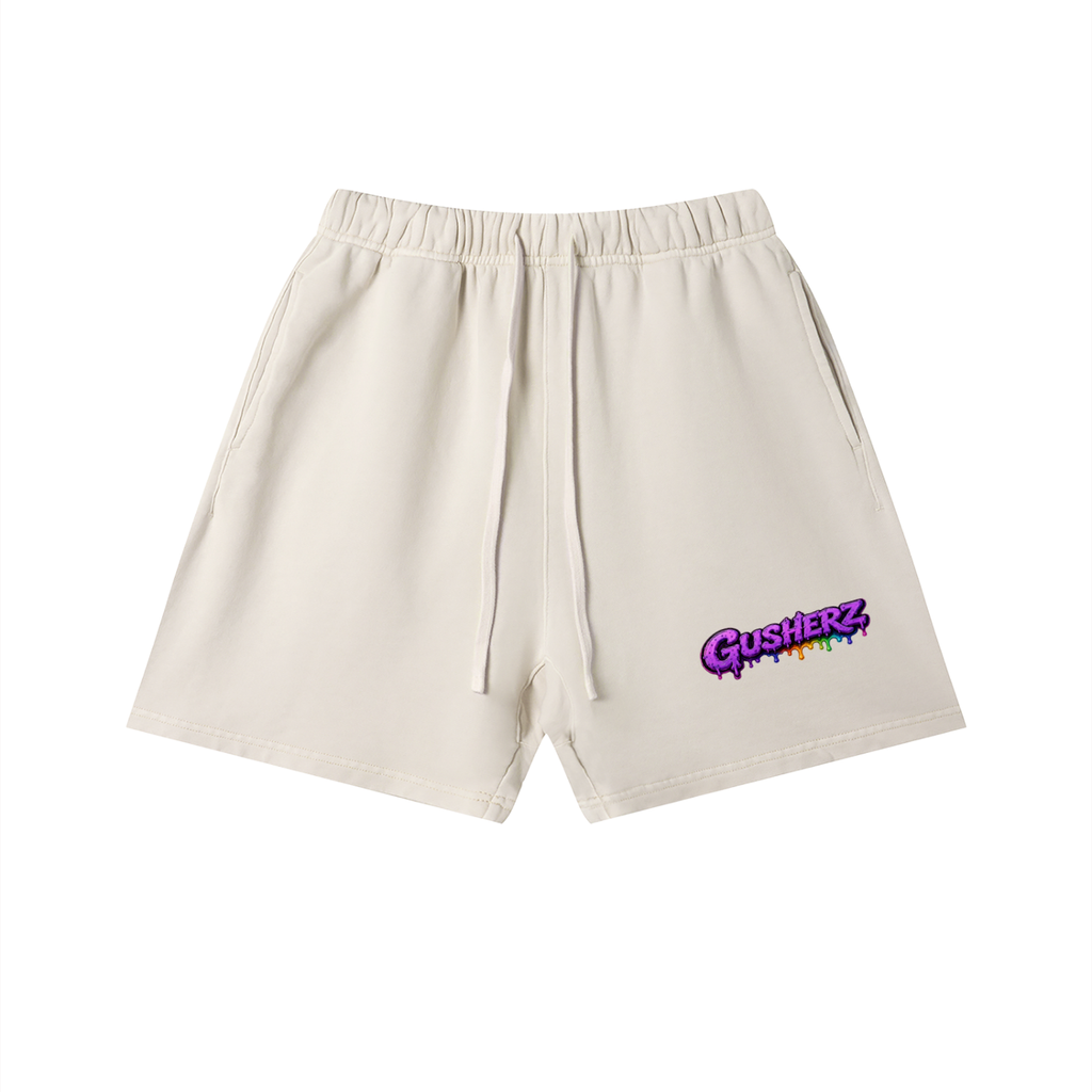 Off white,cream Gusherz athletic shorts with an elastic waistband and drawstring, featuring a purple and rainbow 'Gusherz logo on the lower left leg, shown against a plain white background.