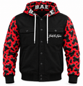 B.A.E. Build An Empire red and black cow print hooded jacket front view, featuring glossy cow-print sleeves and hood, black body, button-front closure, dual chest flap pockets, lower hand pockets, white drawstrings, ribbed cuffs and hem, and Build An Empire chest script.