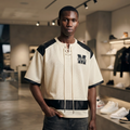Black male model wearing the NFEO Millions Pending oversized boxy mesh raglan tee in a premium luxury streetwear lifestyle setting, showcasing the [FRONT/VIEW], heavyweight 255 GSM breathable mesh fabric, drop shoulder fit, oversized silhouette, premium craftsmanship, and exclusive entrepreneur-inspired design. Styled with matching NFEO Millions Pending platform sneakers for a complete coordinated streetwear collection. Not For Everyone. Built For The Few.