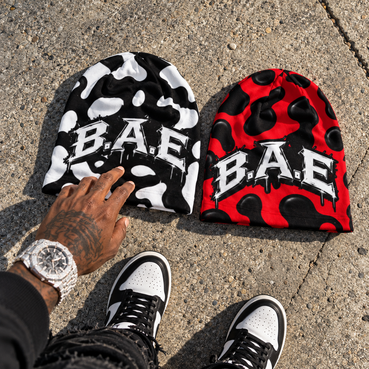 Black & White + Red & Black — Side-by-Side Flat Lay
Black and white and red and black cow print B.A.E. beanies displayed side by side with streetwear sneakers.