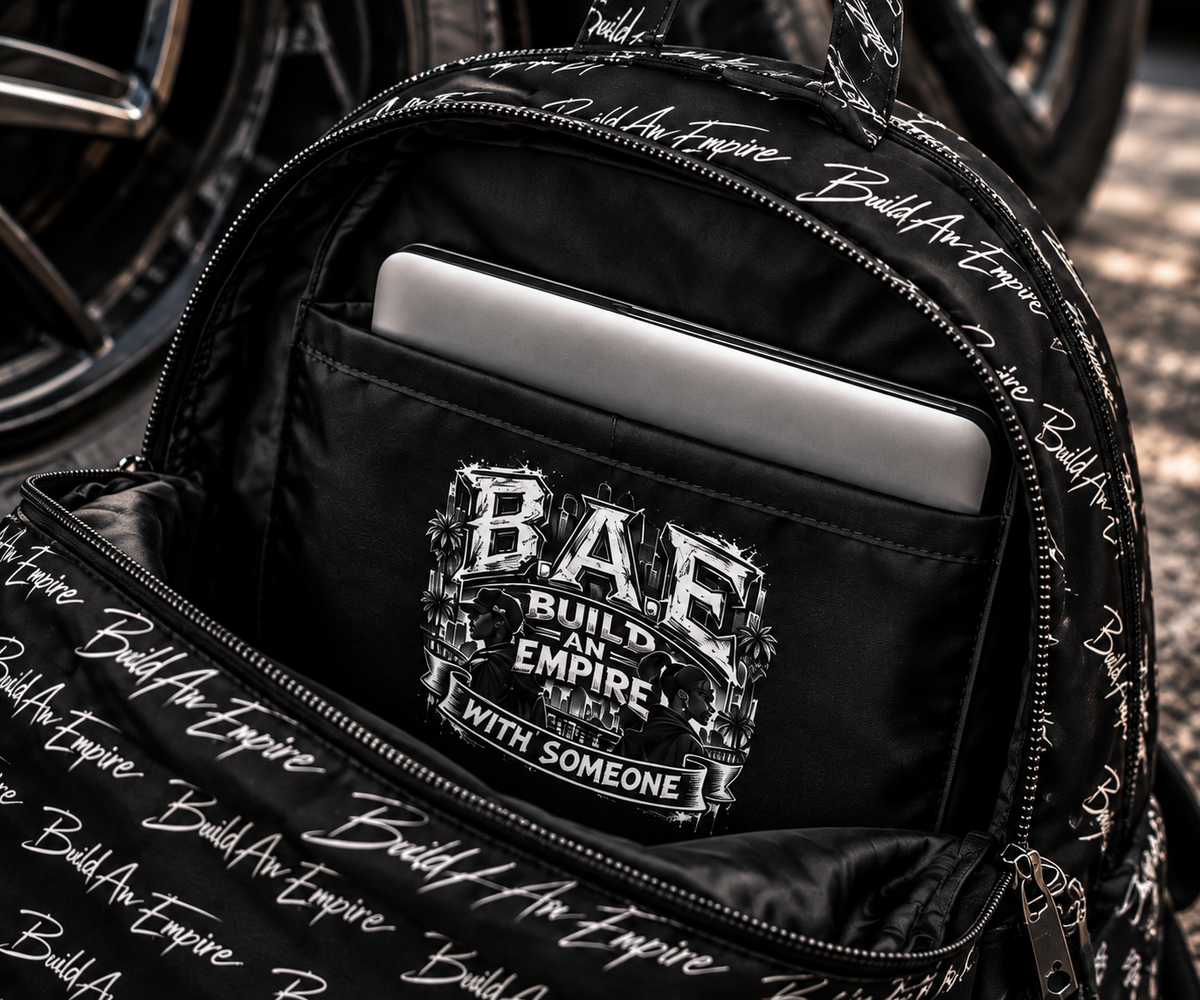 B.A.E. BUILD AN EMPIRE backpack opened to showcase the spacious interior, separate 15-inch laptop compartment, padded storage, zipper construction and signature B.A.E. graphic. Premium water-resistant laptop backpack designed for entrepreneurs, college students, creators, work and everyday carry