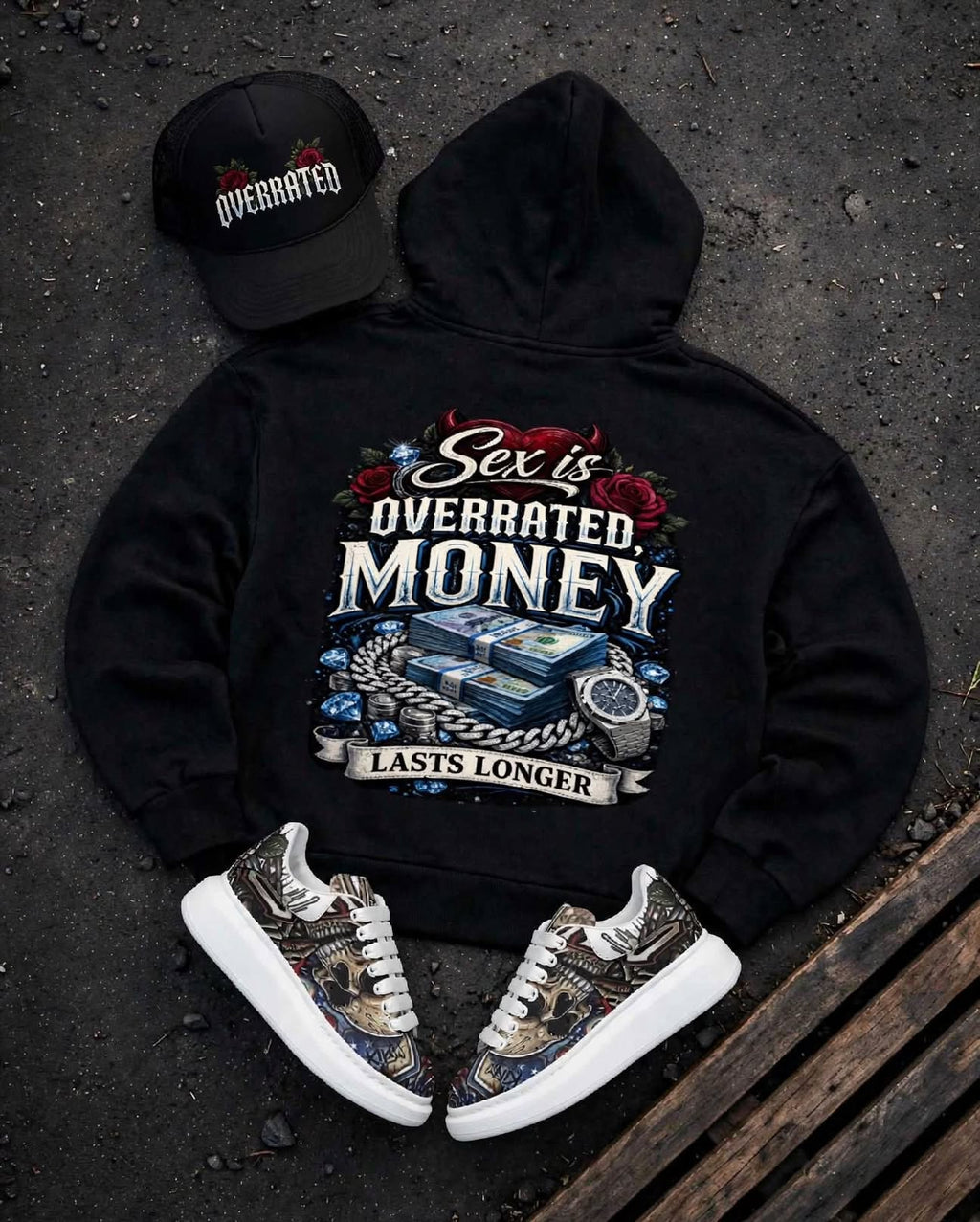 Back view of a Trending premium black Full zip-up hoodie laid flat on a dark textured surface, featuring a large graphic print on the back with the words 'Sex is OVERRATED. MONEY LASTS LONGER' and an illustration of cash, roses, and a watch. Showing Full Overrated collection foam Trucker hat, plus McQueen Graffiti style Platform Sneakers 