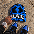 Royal blue and black cow print B.A.E. beanie made from stretch polyester spandex, featuring distressed Build An Empire graffiti lettering, unisex streetwear styling, and a bold all-over print design.